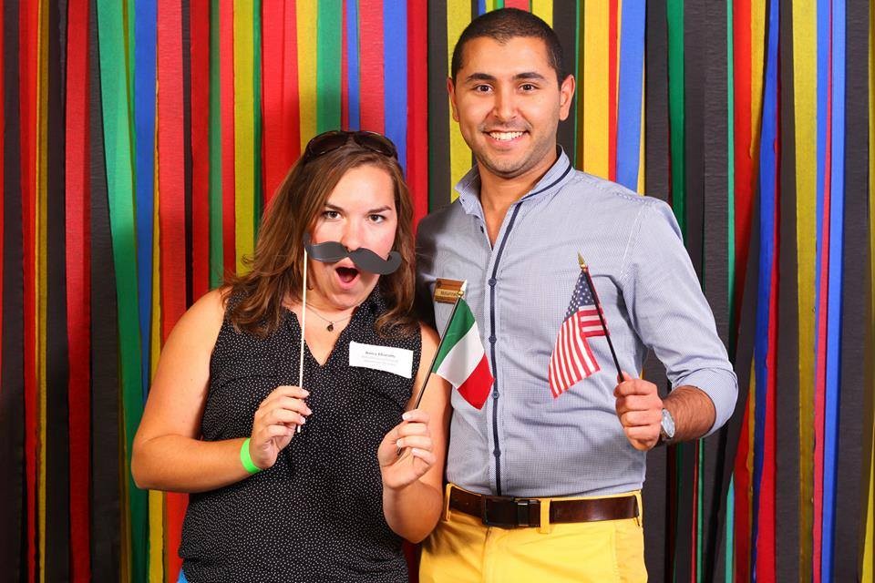 Man and woman smiling holding an Italian and United States of America flag